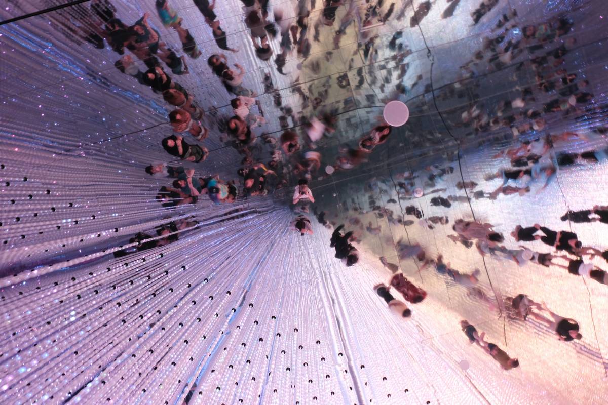 Close-up of hands using motion graphic interactive art controllers to manipulate digital particles in real-time