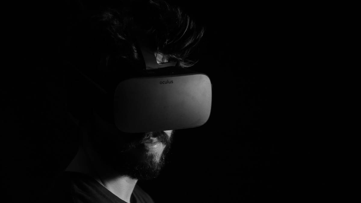 Developer testing interactive reality in motion setup with Valve Index controllers in dimly lit studio
